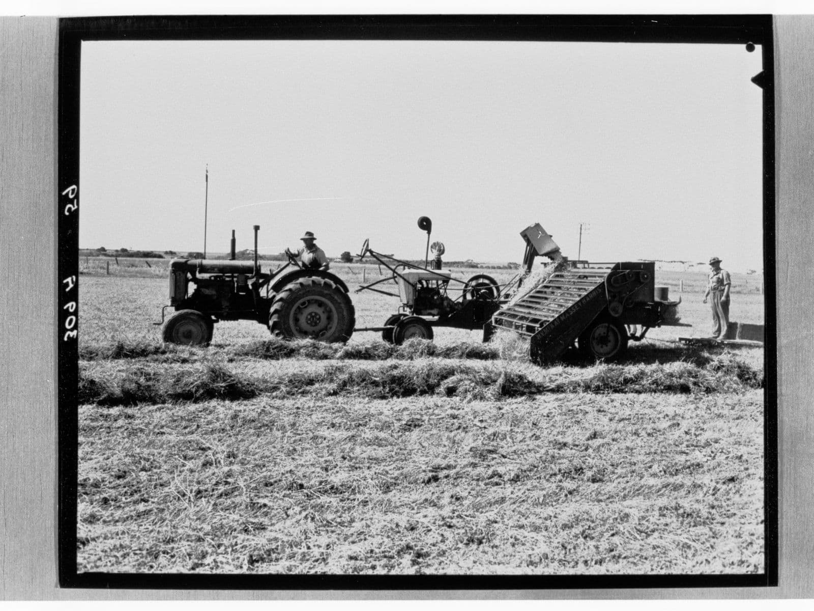 Historical black-and-white photograph of a man on a tractor working a field in South Australia